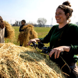 Women laughing and bringing straw